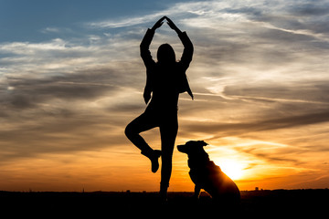 People Silhouette / Girl dances with her dog in the sunset