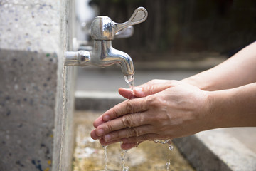Washing of hands  under running water outdoor