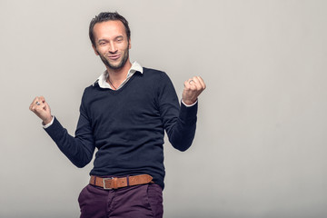 Glücklicher junger Mann jubelt enthusiastisch