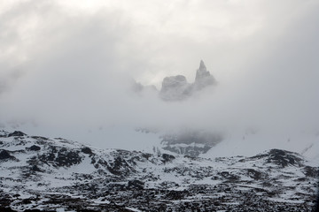 Sharp peak in the clouds. North of Iceland.
