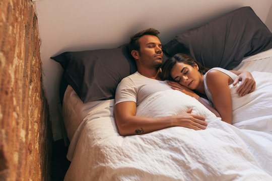 Young Couple Sleeping in Bed with Morning Light