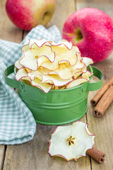 Healthy snack. Homemade dehydrated apple chips on rustic wooden background