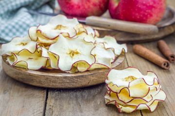 Healthy snack. Homemade dehydrated apple chips on rustic wooden background
