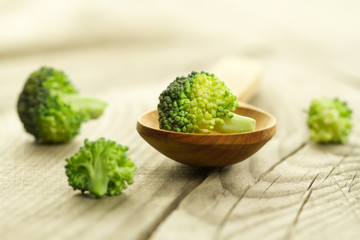 fresh broccoli in a spoon on wooden background. healthy food, vegetarian, slimming, diet.