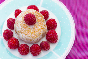 Glazed doughnut with raspberry close up