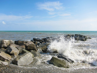 The waves crash with a spray of  rocks