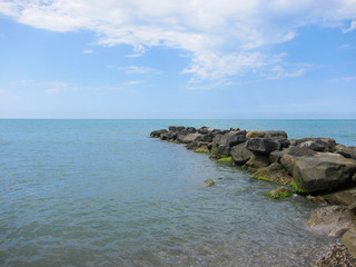 A pile of stones stretches out into the sea
