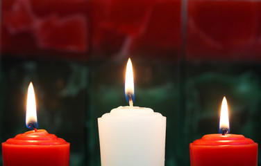 Red and white holiday candles with red and green background