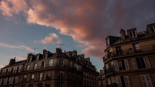 Timelapse video shot in Paris, France. Classic french apartment buildings in the centre of Paris during beautiful sunset. Clouds moving over the sky. 