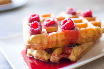 Waffles with raspberries and strawberry syrup