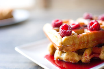 Waffles with raspberries and strawberry syrup