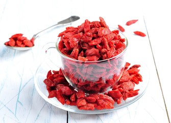 Dried goji berries on a blue and white wooden background