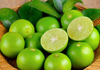 Naklejka na ściany i meble Limes with slices and leaves isolated on white background