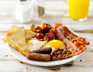 classic english breakfast on rustic table top served with orange juice