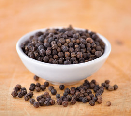  Black peppercorn on wooden background