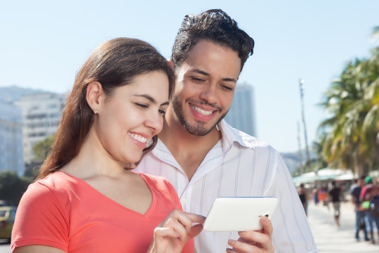 Paar in der Stadt schaut Fotos auf dem Handy an
