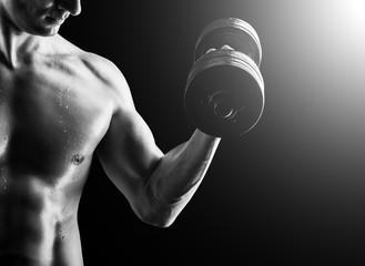 Muscular fitness man - bodybuilder with dumbbell