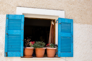Wooden window with blue shutters