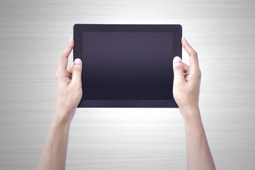 	 Man hand holding tablet tablet screen showing up overhead person wood background concept for...