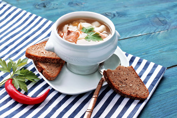 Fish soup on striped napkin and blue wooden background 