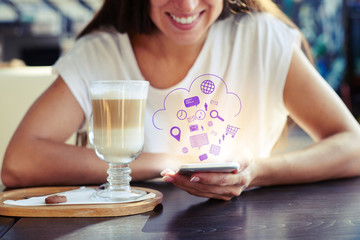 woman sitting in cafe and using her smartphone