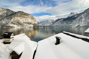 Houses along the Hallstaetter see, Hallstatt Lake with roof covered with snow during winter in...