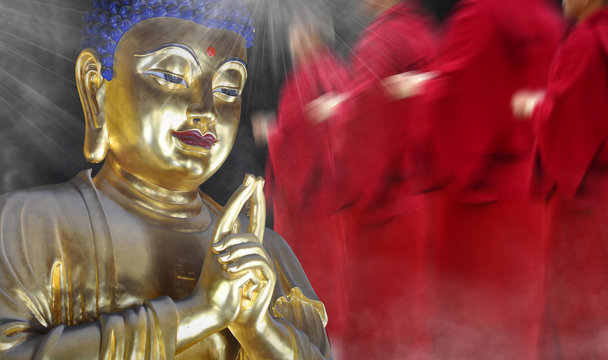 Golden statue inside the asian temple with silhuets of monks