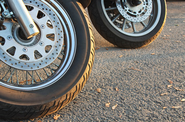 Two motorcycle wheels parked in a road.