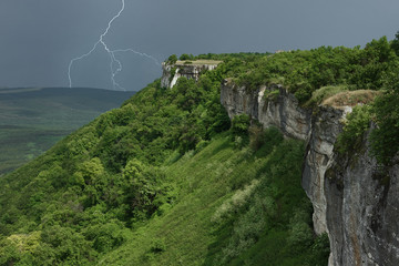 Landscape with thunderstorm in mountains. The approaching storm front over mountains. The dividing...