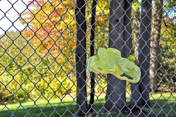 yellow plastic shopping bag in chain link fence