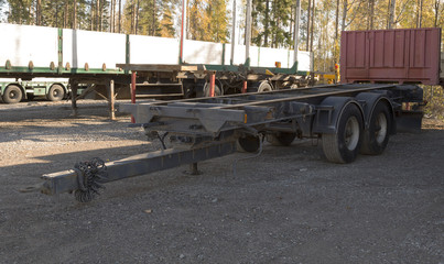 An empty parked trailer on a gravel field