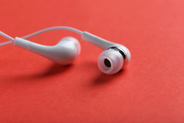 White headphones on a red paper background