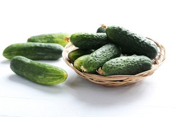 Fresh cucumbers on white wooden background