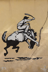 Fototapeta na wymiar Graffiti of rodeo, man riding horse. Old Wall, Argentina