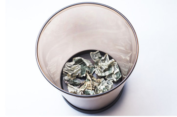 Clear Wastebasket With Crumpled Money Thrown Away In It