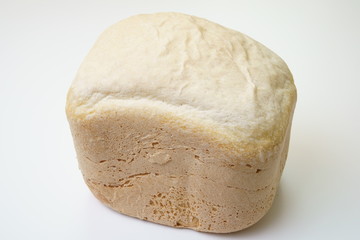 Homemade bread produced by bread making machine on white/gray background