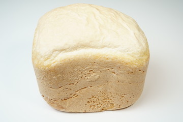 Homemade bread produced by bread making machine on white/gray background