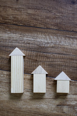 wooden toy houses in a row according to growth. wooden houses made of toy blocks placed in a row according to size on a beautiful wooden background. chart for statistics