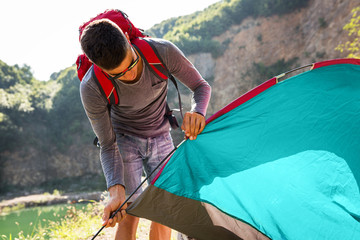 Young camper setting up tent outdoors