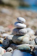Close-up shot of natural stones stacked on stones. The rocks are illuminated on the right side, creating a distinct drop shadow. The background is boke.