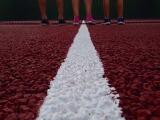 linea en una pista de tenis con las piernas de unos niños al final de la linea