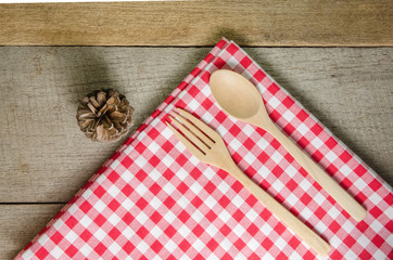 Red and white tablecloth, wooden spoons on wood table