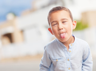 portrait of a little boy sticking out tongue © asierromero