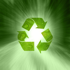 Creative green color recycle symbol on abstract green motion blurred background. Lovely recycle symbol with added leaf droplet texture.