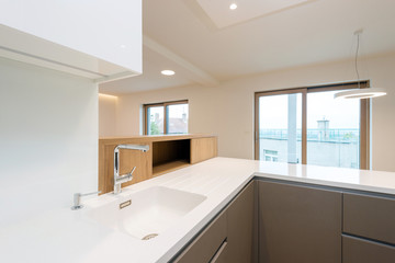 Sink with tap on white worktop of contemporary kitchen