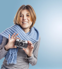 portrait of a pretty young woman holding her camera and wearing a scarf