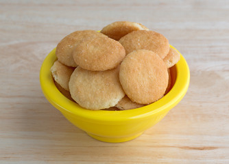 Bowl of small vanilla wafer cookies on table