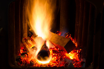 Dry firewood in flames. The furnace wood stove. Dry firewood, sparks, red-hot coals and flames.