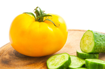cucumber with slices and tomato on cutting board