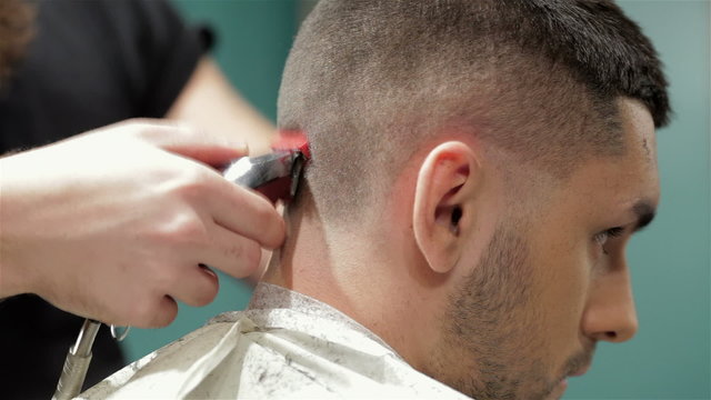 Bearded brutal man in a barber shop